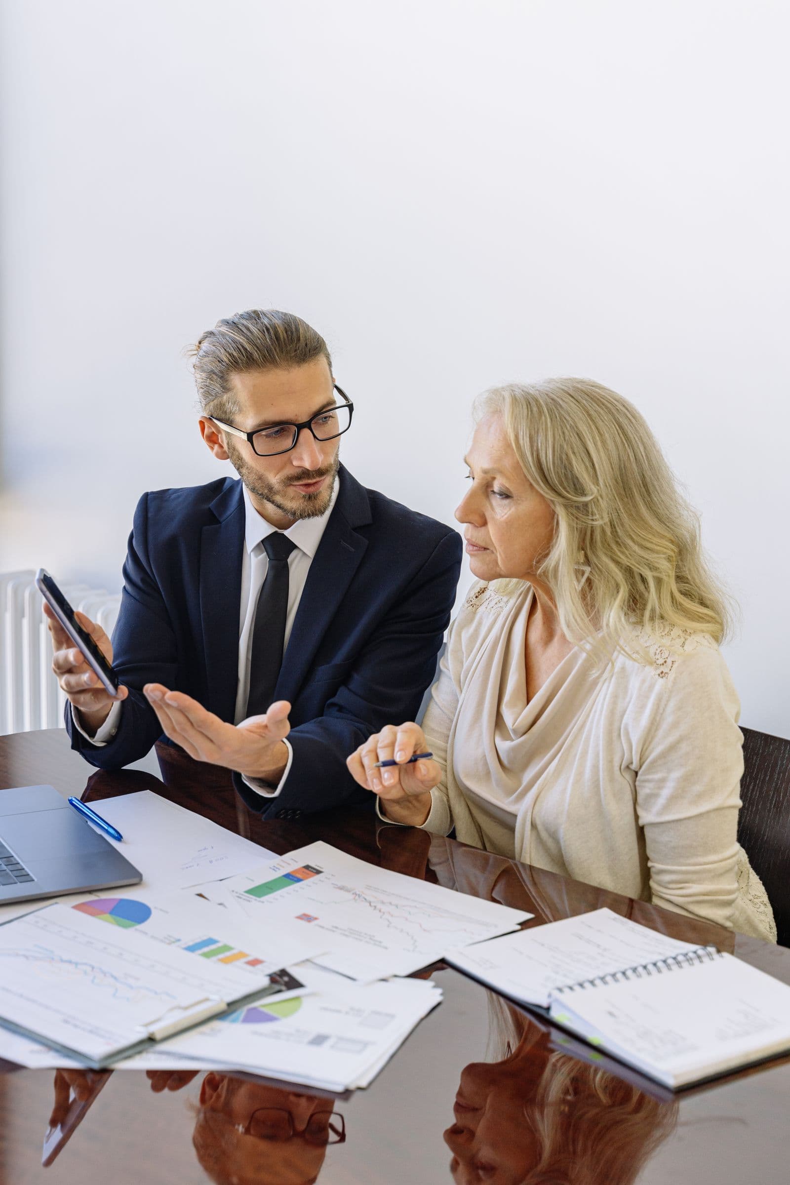 An advisor showing a savings plan to a client on a phone